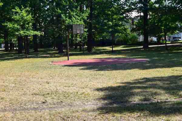 A small circular basketball court in a park.