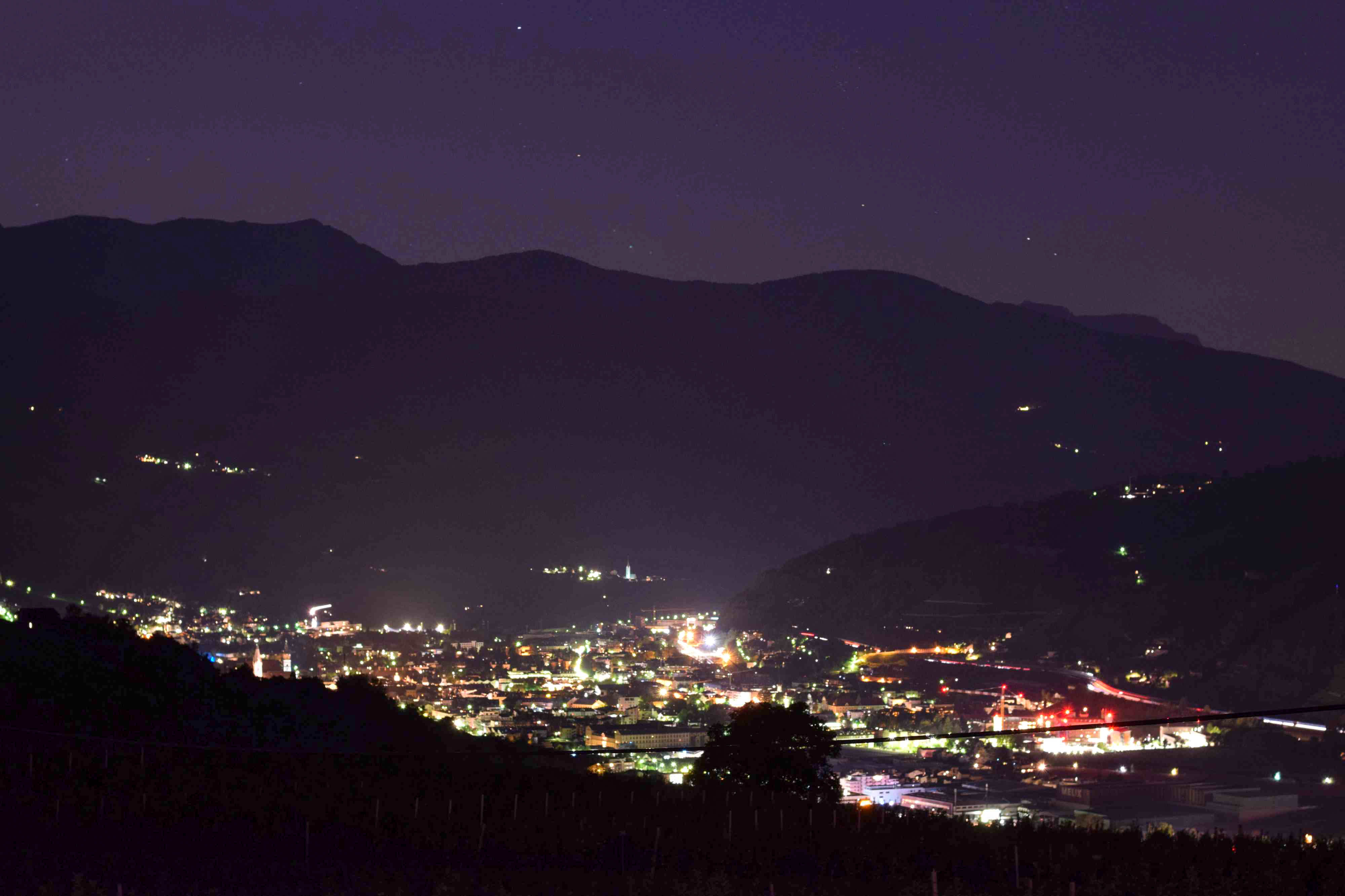 A valley with village lights at night from above.