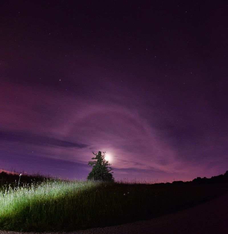 A picture of the moon at night with a corona around.