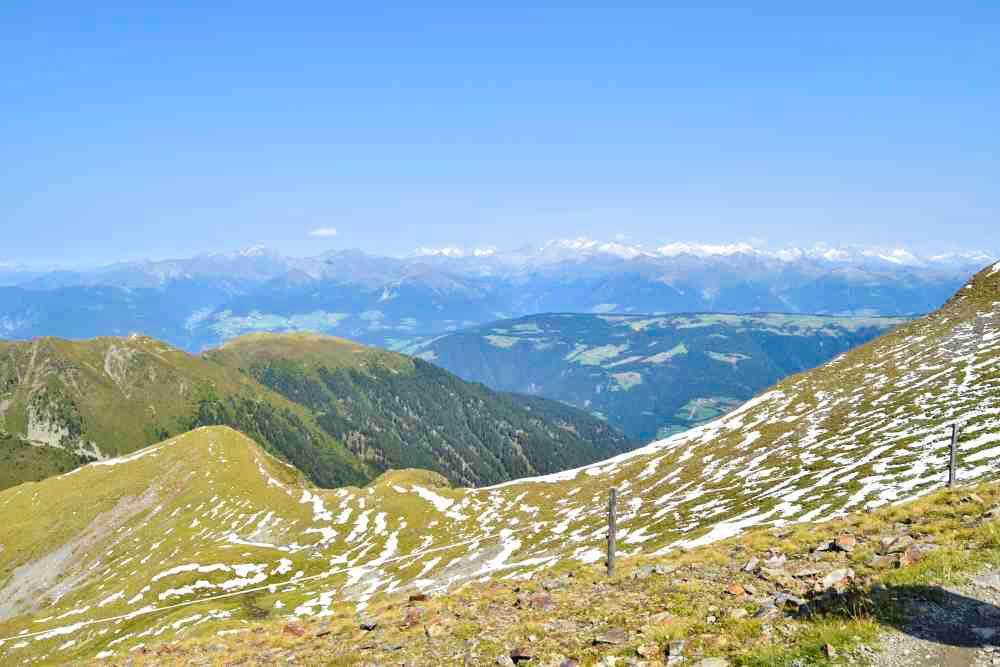 Some green mountains with a bit of snow